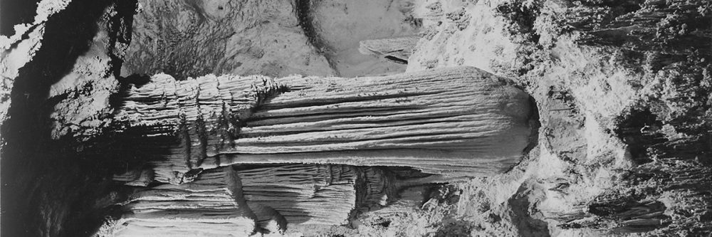 Formations above Green Lake, Large stalagmite with draped stalactite above it. One of the principal features in the King's Palace, Carlsbad Caverns National Park, New Mexico.